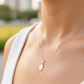Cuello de modelo usando una cadena con un dije de la Virgen de Guadalupe en oro amarillo de 18 quilates de Joyería Caracas.