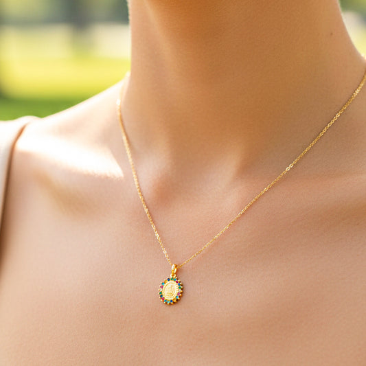 Cuello de modelo usando una cadena con un dije en forma de la Virgen de Guadalupe multicolor en oro amarillo de 18 quilates de Joyería Caracas.