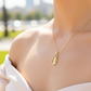 Cuello de modelo usando una cadena con un dije de la Virgen de Guadalupe en oro amarillo de 18 quilates con cristales de Joyería Caracas.