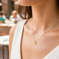 Cuello de modelo usando una cadena con un dije en forma de hueso en oro amarillo de 18 quilates de Joyería Caracas.