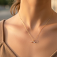 Cuello de modelo usando una cadena con un dije en forma de infinito en oro amarillo de 18 quilates con cristales de Joyería Caracas.