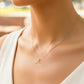 Cuello de modelo usando una cadena con un dije en forma de palabra Jesús mini en oro amarillo de 18 quilates de Joyería Caracas.