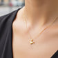 Cuello de modelo usando una cadena con un dije en forma de lámpara de enfermería en oro amarillo de 18 quilates con cristales de Joyería Caracas.