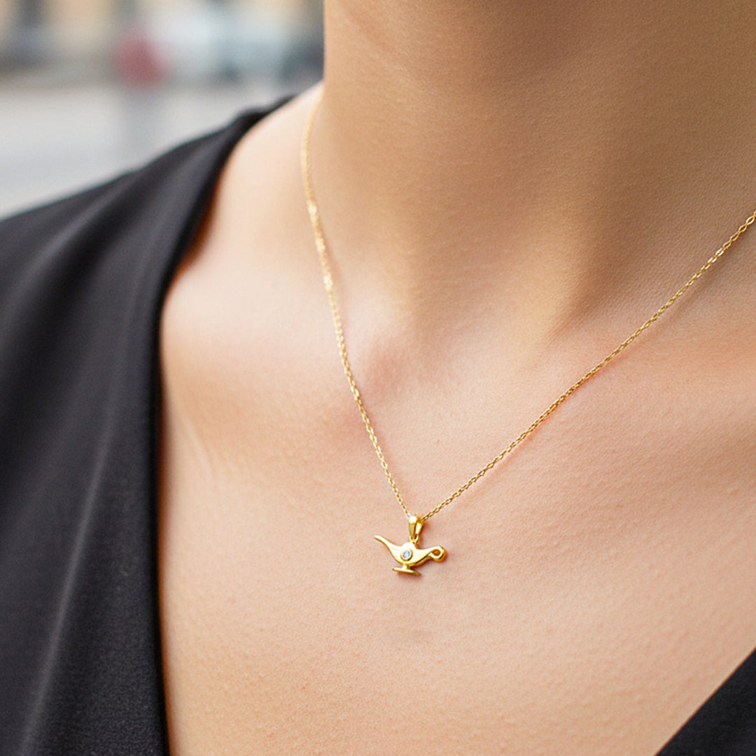 Cuello de modelo usando una cadena con un dije en forma de lámpara de enfermería en oro amarillo de 18 quilates con cristales de Joyería Caracas.