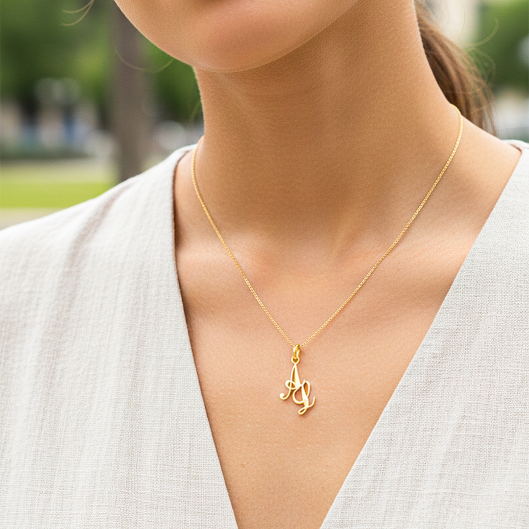Cuello de modelo usando una cadena con un dije de la letra A L cursiva en oro amarillo de 18 quilates de Joyería Caracas.