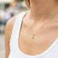 Cuello de modelo usando una cadena con un dije de la letra A en oro amarillo de 18 quilates con cristales de Joyería Caracas.