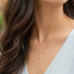 Cuello de modelo usando una cadena con un dije en forma de la letra B en oro amarillo de 18 quilates con cristales de Joyería Caracas.