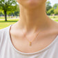 Cuello de modelo usando una cadena con un dije en forma de la letra C en oro amarillo de 18 quilates con cristales de Joyería Caracas.