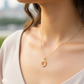 Cuello de modelo usando una cadena con un dije de la letra C en oro amarillo de 18 quilates con cristales de Joyería Caracas.