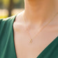 Cuello de modelo usando una cadena con un dije en forma de la letra D en oro amarillo de 18 quilates con cristales de Joyería Caracas.