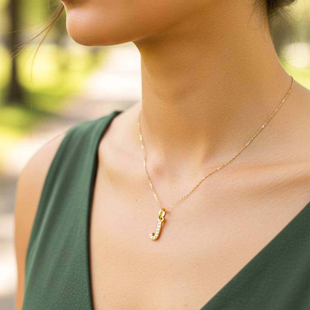 Cuello de modelo usando una cadena con un dije de la letra L oro amarillo de 18 quilates con cristales de Joyería Caracas.