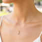 Cuello de modelo usando una cadena con un dije de la letra K oro amarillo de 18 quilates con cristales de Joyería Caracas.