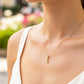 Cuello de modelo usando una cadena con un dije de la letra L en oro amarillo de 18 quilates con cristales de Joyería Caracas.