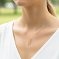 Cuello de modelo usando una cadena con un dije de la letra L cursiva en oro amarillo de 18 quilates de Joyería Caracas.