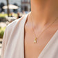 Cuello de modelo usando una cadena con un dije de la letra M en oro amarillo de 18 quilates con cristales de Joyería Caracas.