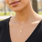 Cuello de modelo usando una cadena con un dije en forma de la letra N en oro amarillo de 18 quilates con cristales de Joyería Caracas.