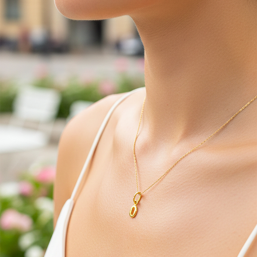 Cuello de modelo usando una cadena con un dije en forma de la letra O mini en oro amarillo de 18 quilates de Joyería Caracas.