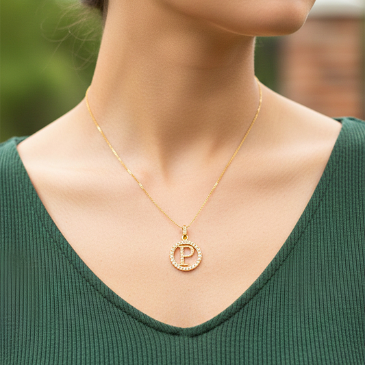 Cuello de modelo usando una cadena con un dije de la letra P en oro amarillo de 18 quilates con cristales de Joyería Caracas.