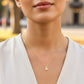 Cuello de modelo usando una cadena con un dije en forma de la letra R en oro amarillo de 18 quilates con cristales de Joyería Caracas.