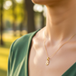 Cuello de modelo usando una cadena con un dije en forma de la letra S en oro amarillo de 18 quilates de Joyería Caracas.
