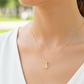 Cuello de modelo usando una cadena con un dije en forma de la letra S en oro amarillo de 18 quilates con cristales de Joyería Caracas.