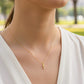 Cuello de modelo usando una cadena con un dije en forma de letra T en oro amarillo de 18 quilates de Joyería Caracas.