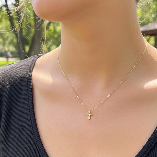 Cuello de modelo usando una cadena con un dije en forma de la letra T en oro amarillo de 18 quilates con cristales de Joyería Caracas.