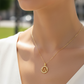 Cuello de modelo usando una cadena con un dije de la letra W en oro amarillo de 18 quilates con cristales de Joyería Caracas.