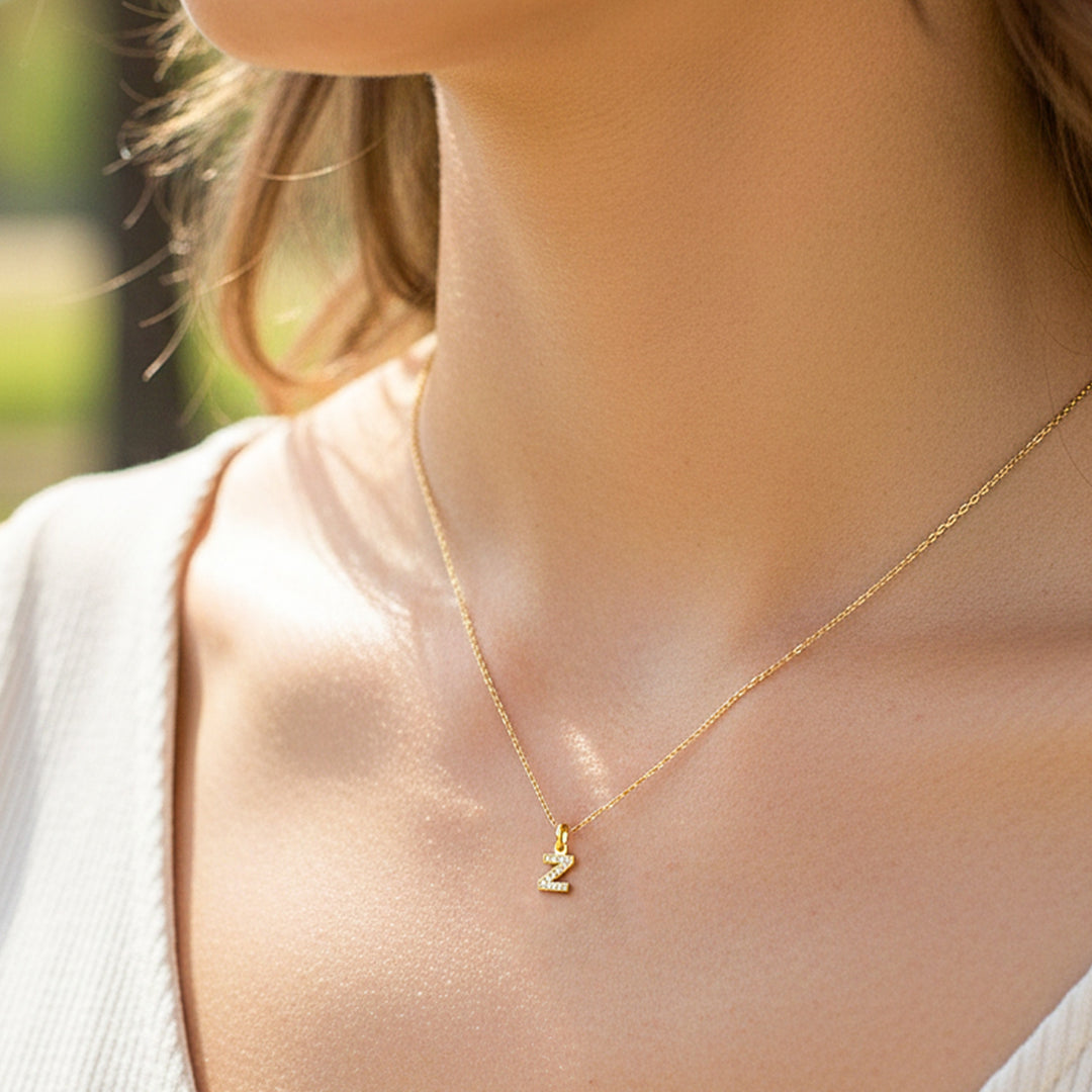 Cuello de modelo usando una cadena con un dije en forma de letra Z en oro amarillo de 18 quilates con cristales de Joyería Caracas.