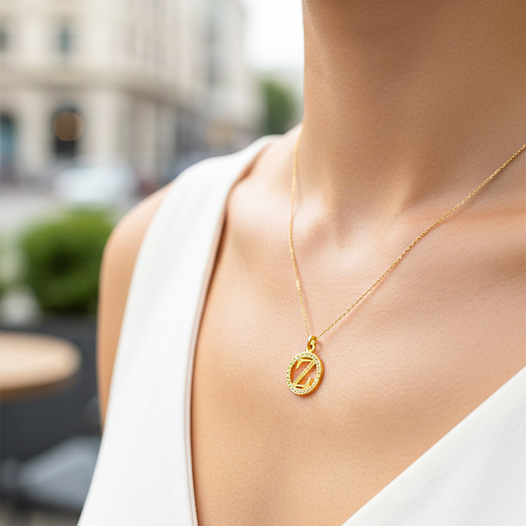 Cuello de modelo usando una cadena con un dije de la letra Z en oro amarillo de 18 quilates con cristales de Joyería Caracas.