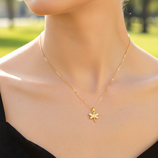 Cuello de modelo usando una cadena con un dije en forma de libélula en oro amarillo de 18 quilates con cristales de Joyería Caracas.