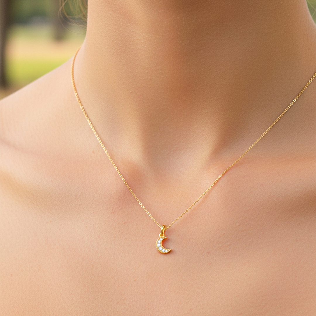 Cuello de modelo usando una cadena con un dije en forma de luna en oro amarillo de 18 quilates con cristales de Joyería Caracas.