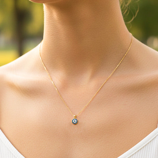 Cuello de modelo usando una cadena con un dije en forma de mándala en oro amarillo de 18 quilates con cristales azules y blancos de Joyería Caracas.