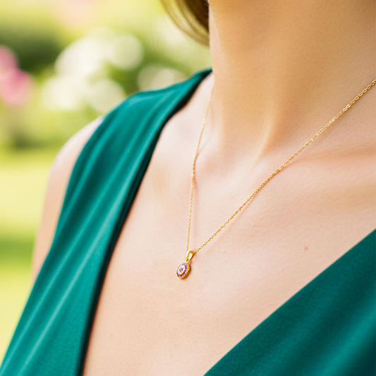Cuello de modelo usando una cadena con un dije en forma de mándala en oro amarillo de 18 quilates con cristales blancos y rojos de Joyería Caracas.