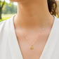 Cuello de modelo usando una cadena con un dije en forma de mándala en oro amarillo de 18 quilates con cristales de Joyería Caracas.