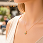 Cuello de modelo usando una cadena con un dije en forma de mariposa en oro amarillo de 18 quilates con cristales azules de Joyería Caracas.