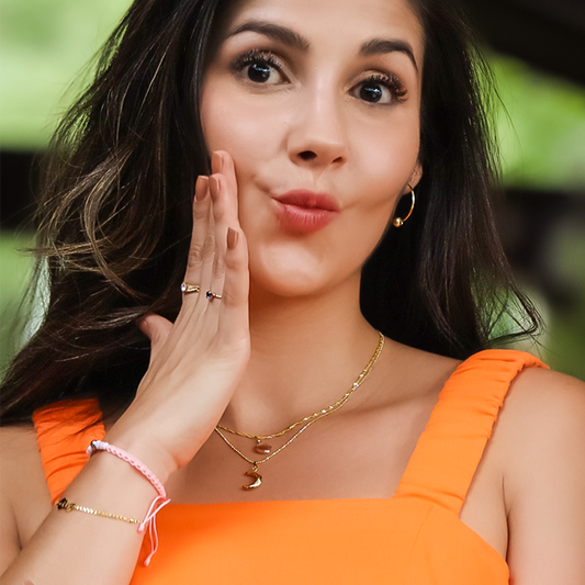 Cuello de mujer usando una cadena con un dije en forma de luna en oro amarillo de 18 quilates. 