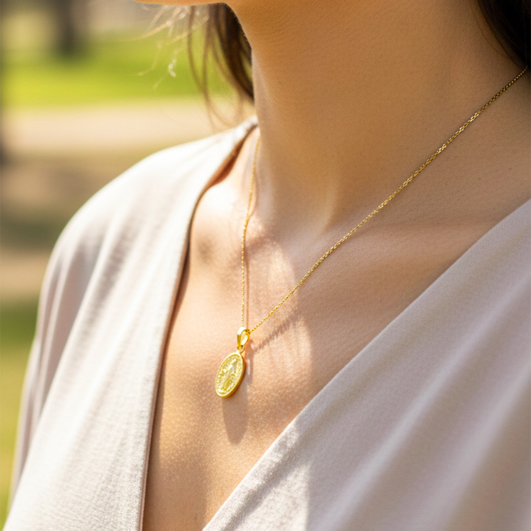 Cuello de modelo usando una cadena con un dije de la Virgen Milagrosa en oro amarillo de 18 quilates de Joyería Caracas.