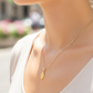 Cuello de modelo usando una cadena con un dije de la Virgen Milagrosa en oro amarillo de 18 quilates de Joyería Caracas.
