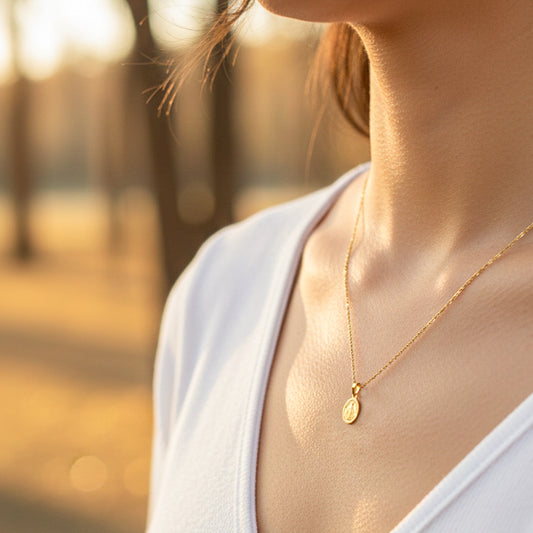 Cuello de modelo usando una cadena con un dije de la Virgen Milagrosa en oro amarillo de 18 quilates de Joyería Caracas.