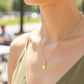 Cuello de modelo usando una cadena con un dije de la Virgen Milagrosa en oro amarillo de 18 quilates de Joyería Caracas.