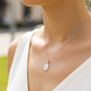 Cuello de modelo usando una cadena con un dije en forma de la Virgen Milagrosa en oro blanco de 18 quilates de Joyería Caracas.