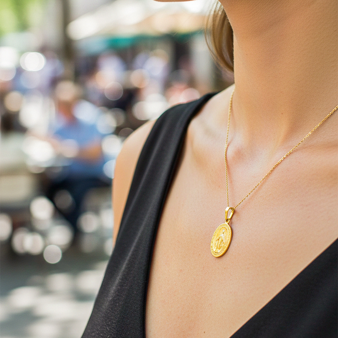Cuello de modelo usando una cadena con un dije de la Virgen Milagrosa en oro amarillo de 18 quilates de Joyería Caracas.