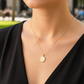 Cuello de modelo usando una cadena con un dije de la Virgen Milagrosa en oro amarillo de 18 quilates con cristales de Joyería Caracas.