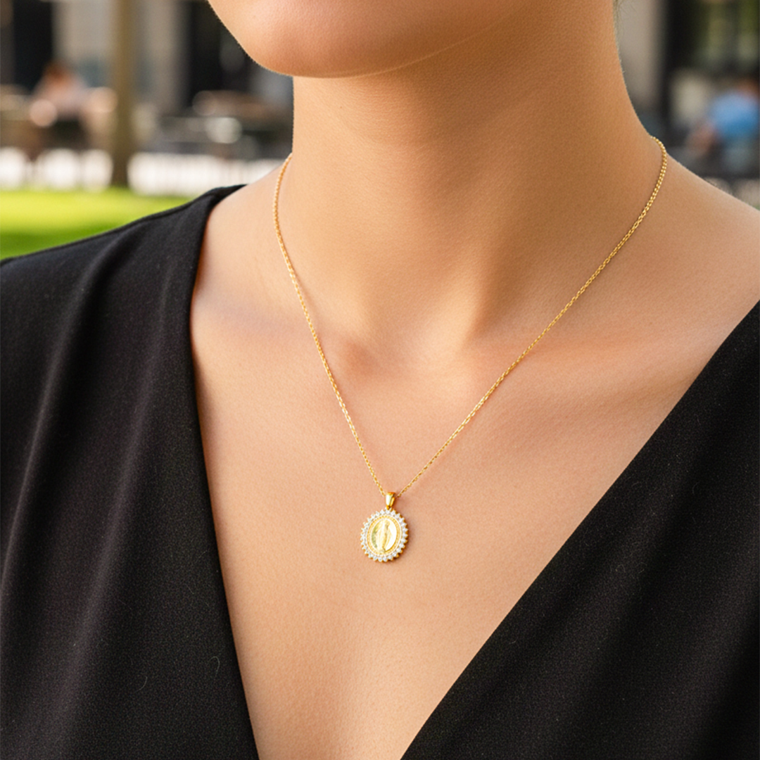 Cuello de modelo usando una cadena con un dije de la Virgen Milagrosa en oro amarillo de 18 quilates con cristales de Joyería Caracas.