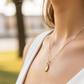 Cuello de modelo usando una cadena con un dije la Virgen Milagrosa en oro amarillo de 18 quilates con cristales de Joyería Caracas.