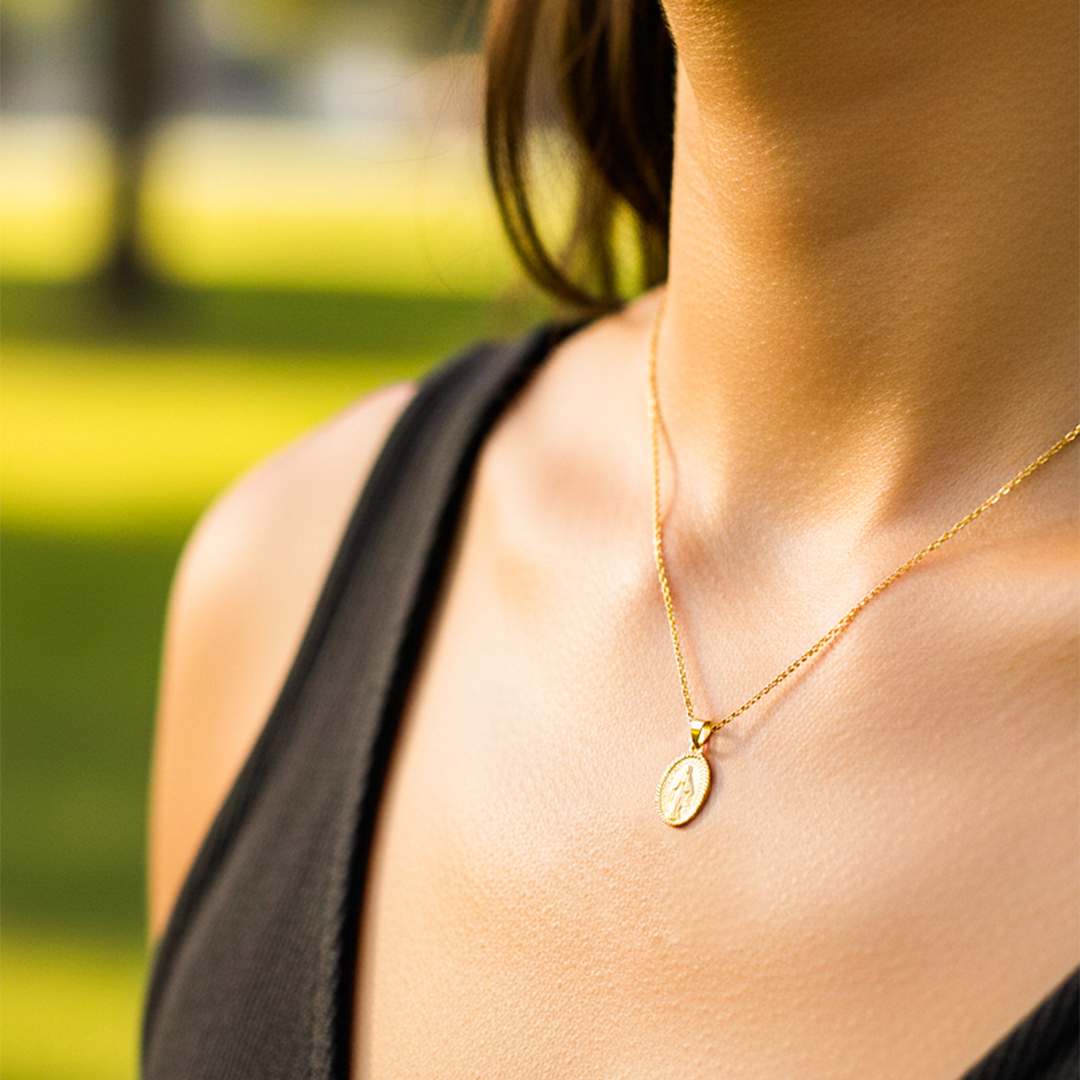 Cuello de modelo usando una cadena con un dije de la Virgen Milagrosa facetada oro amarillo de 18 quilates de Joyería Caracas.