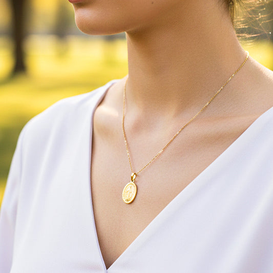 Cuello de modelo usando una cadena con un dije en forma de la Virgen Milagrosa en oro amarillo de 18 quilates de Joyería Caracas.