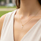 Cuello de modelo usando una cadena con un dije en forma de cruz plana en oro amarillo de 18 quilates de Joyería Caracas.