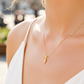 Cuello de modelo usando una cadena con un dije en forma de mini raqueta de tenis en oro amarillo de 18 quilates con cristales de Joyería Caracas.